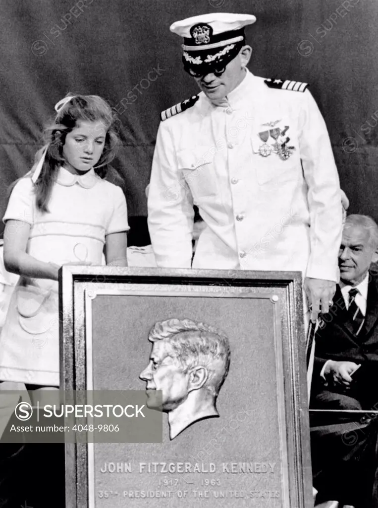 Caroline Kennedy with Capt. Earl Yates, commander of the newly commissioned aircraft carrier, USS John F. Kennedy. She presented him with a commemorative relief of her father, President John F. Kennedy. July 27, 1968.
