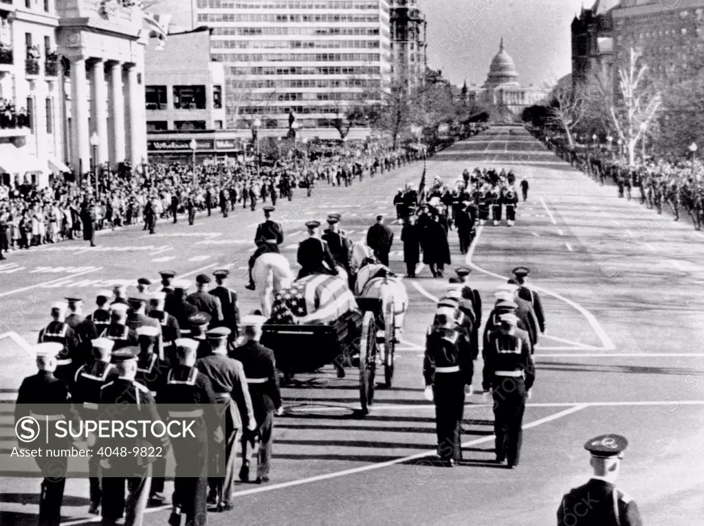 President Kennedys flag-draped coffin moves slowly past mourning crowds. The funeral procession was on Pennsylvania Avenue traveling to the Capitol, where the assassinated President would lie in state for one day before his funeral. Nov. 24, 1963.