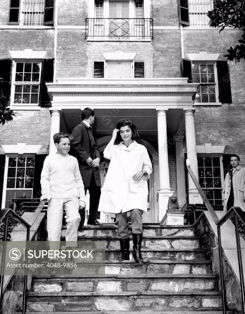 Jacqueline Kennedy, moving into her Federal Period Georgetown home. At her side is Joe Kennedy, son of Attorney General Robert and Ethel Kennedy. Person at center is unidentified. Feb. 1, 1964.