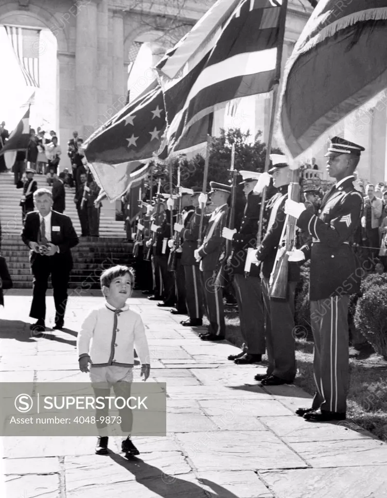 Young John Kennedy Jr., the President's son, 'inspects' the honor guard. He was at Arlington National Cemetery where his father placed a wreath at the Tombs of the Unknown on Veterans Day. Nov. 11, 1963.