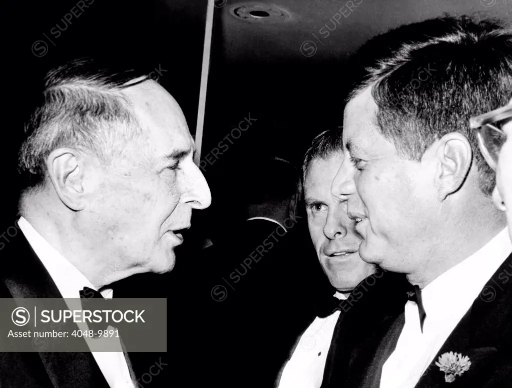 President Kennedy talks with Gen. Douglas MacArthur (left). They were at the National Football Hall of Fame dinner at the Waldorf Astoria. In his speech, the President lamented that America's number one national sport seems to be sitting and watching somebody else get exercise. Dec. 5, 1961.