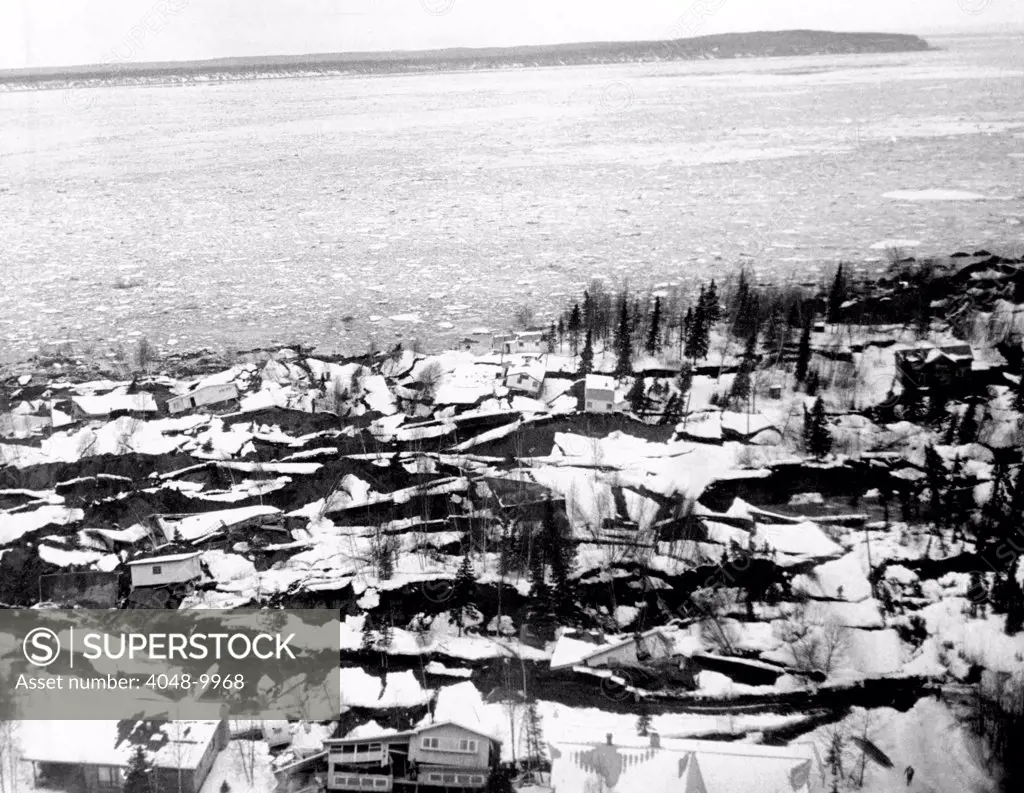 1964 Alaska Earthquake. Aerial view of the Anchorage residential area of Turnagail shows destruction caused by the up thrust of the Good Friday earthquake. The jagged striations are newly exposed earth. The snow-covered earth was the Pre-Earthquake surfaces. In background is ice-covered Cook inlet. March 27, 1964