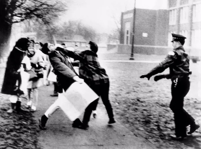 A female for school segregation punches a pro-integration demonstrator in the face. Both were outside Mount Greenwood elementary school in Chicago. Police arrested two men (including the one getting punched), and charged them with disorderly conduct. Jan. 31, 1968.