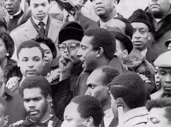 Profile of Stokely Carmichael speaking and gesturing in midst of crowd demonstrating near the Capitol in Washington, DC. January 10, 1967.