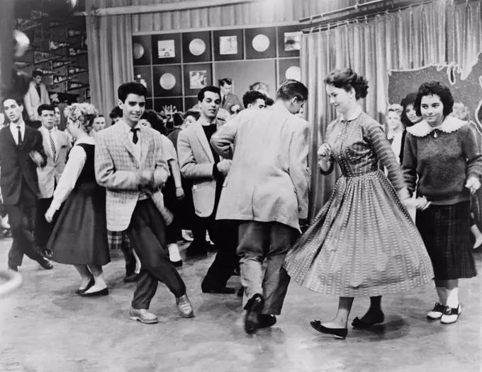Teens dancing on Dick Clark's American Bandstand in 1961. Some are dancing the Twist, recently popularized by Chubby Checker's 1960 single, 'The Twist'.