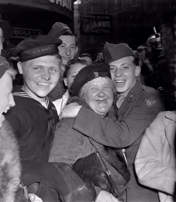 V-E Day celebration in Piccadilly Circus, London, May 7, 1945. A jubilant American soldier hugs a motherly English woman celebrating Germany's unconditional surrender. World War 2. (BSLOC_2014_8_105)