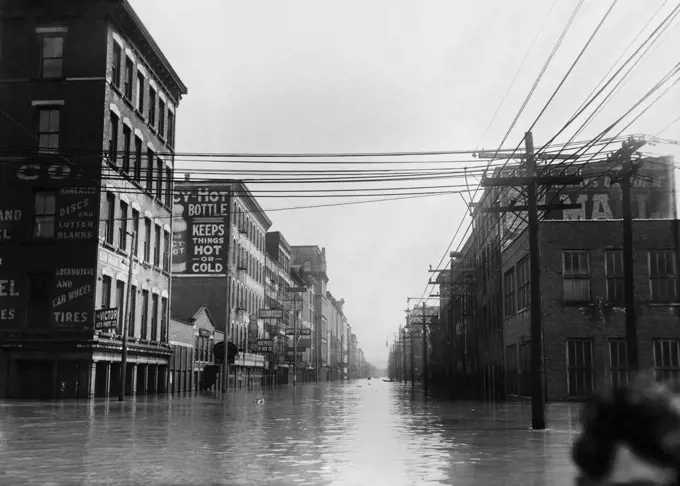 The Great Flood of 1913 was Ohio's greatest weather disaster of the early 20th century. Photo shows flooded warehouses Elm St., looking north, Cincinnati, Ohio. A cropped head of a woman is in lower right (BSLOC_2017_17_94)