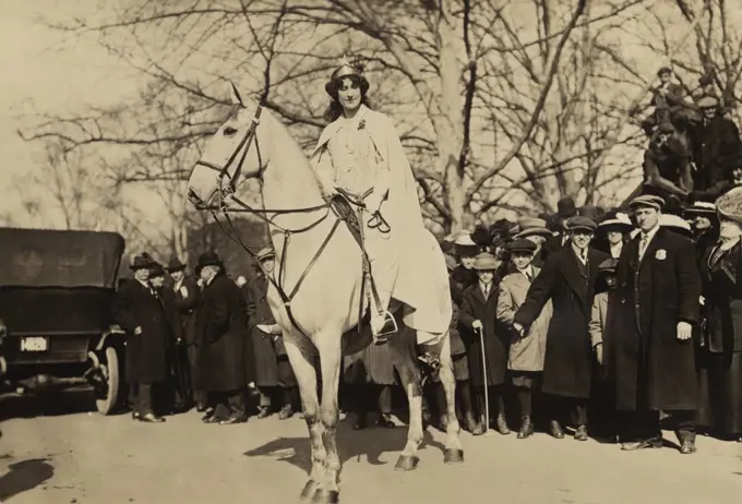 Inez Milholland, wearing white robes and a crown riding a white horse as the 'Herald' in the Women's Suffrage parade of March 3, 1913, the day prior to Woodrow Wilson's inauguration. It was the last major suffrage demonstration to use such theatrical costumes.