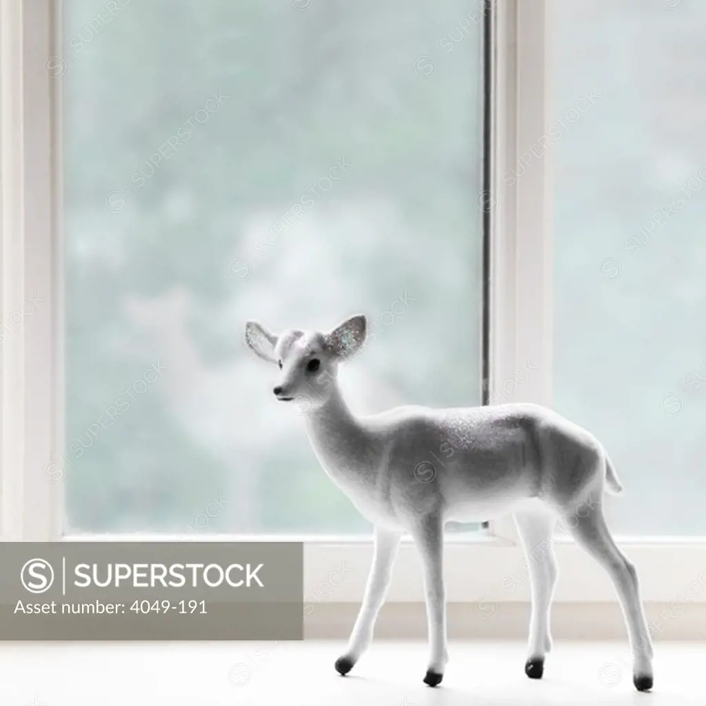 Close-up of a figurine of a fawn at a window sill