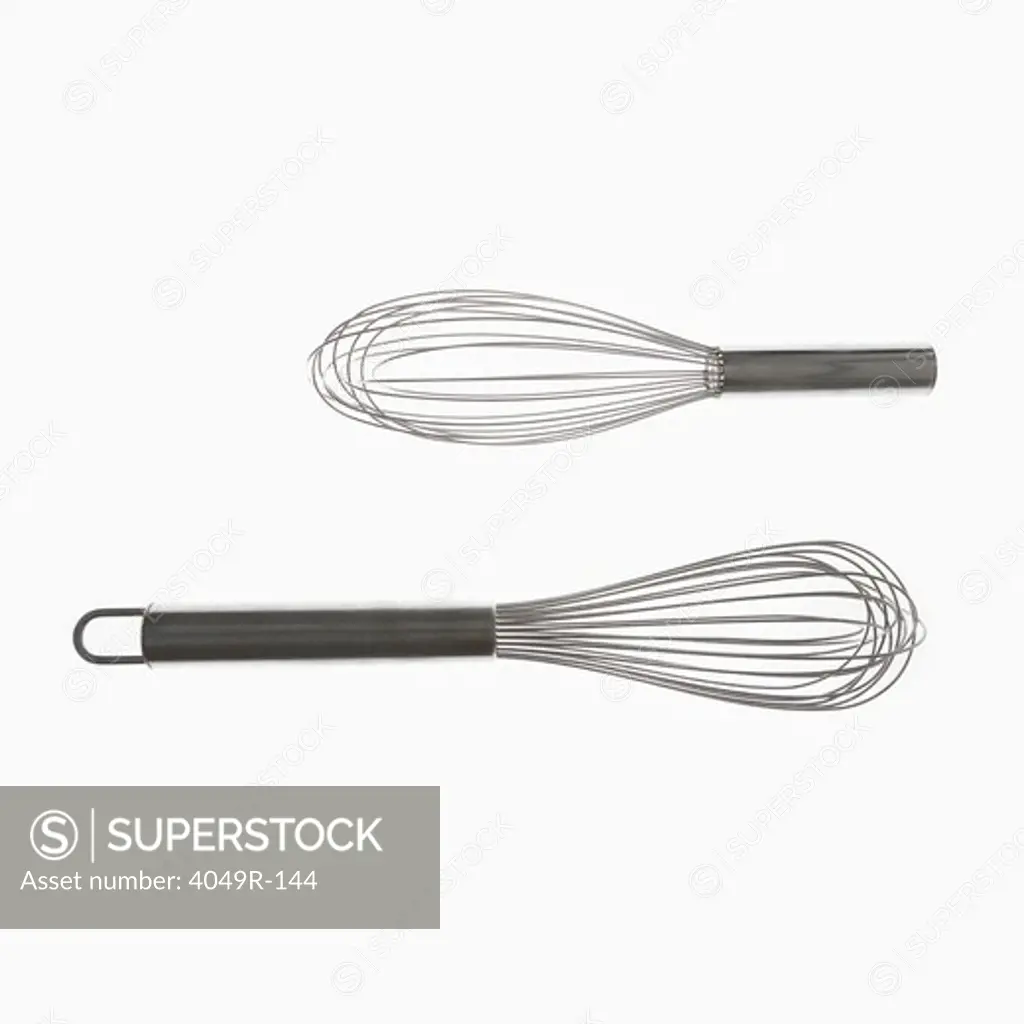 Close-up of two wire whisks