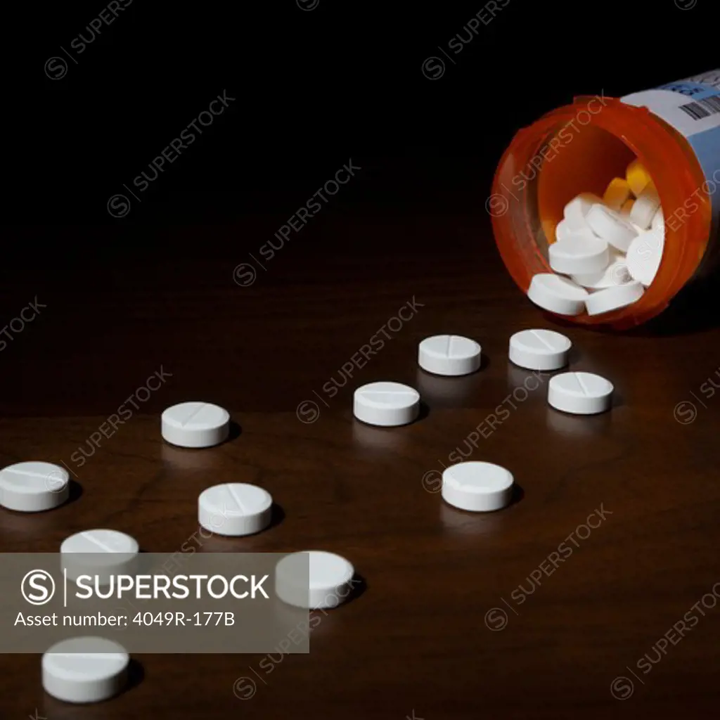Close-up of pills spilling out of a bottle