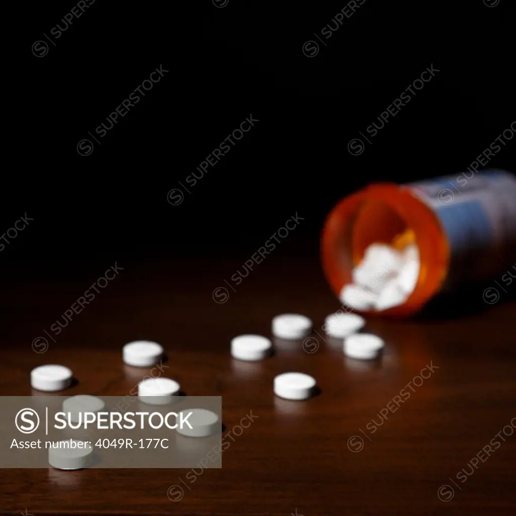 Close-up of pills spilling out of a bottle