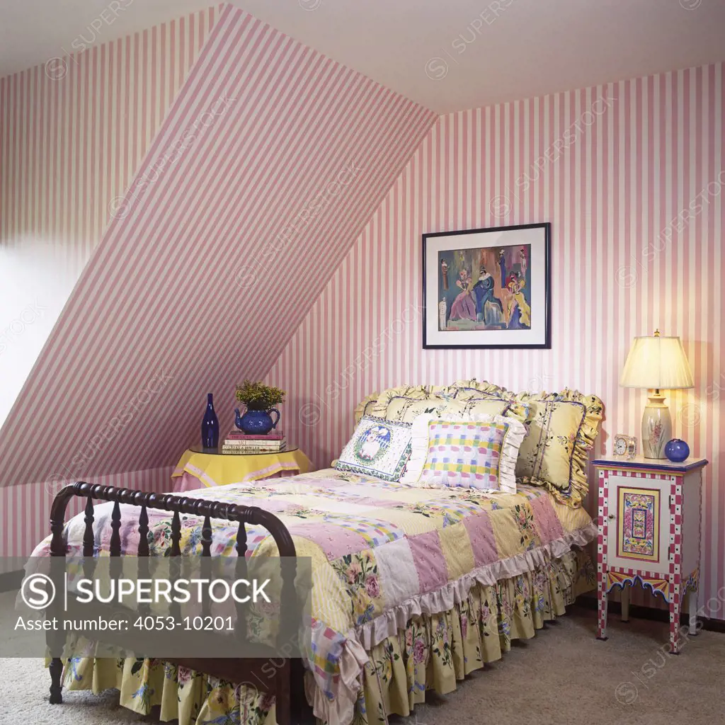 CHILDREN'S BEDROOM: Pink stripe wallpaper upstairs bedroom, colorful hand painted side table, bed clothes are multi colors of cream, pink, white and yellow.