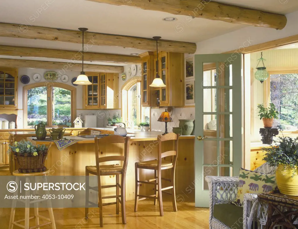 KITCHENS - Country, log beamed ceiling, pine cabinets, pine floors, peninsula and center island, sage green door