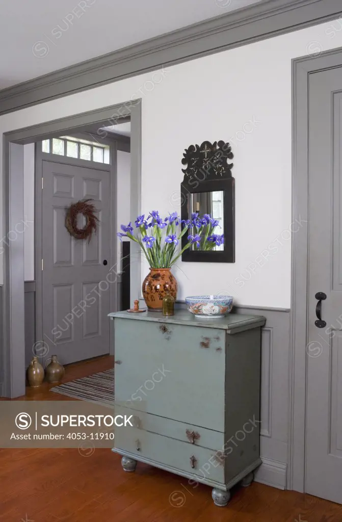 LIVING ROOM DETAILS: Pale blue painted cabinet, vase of iris, carved mirror, greasy painted trim, simple lines