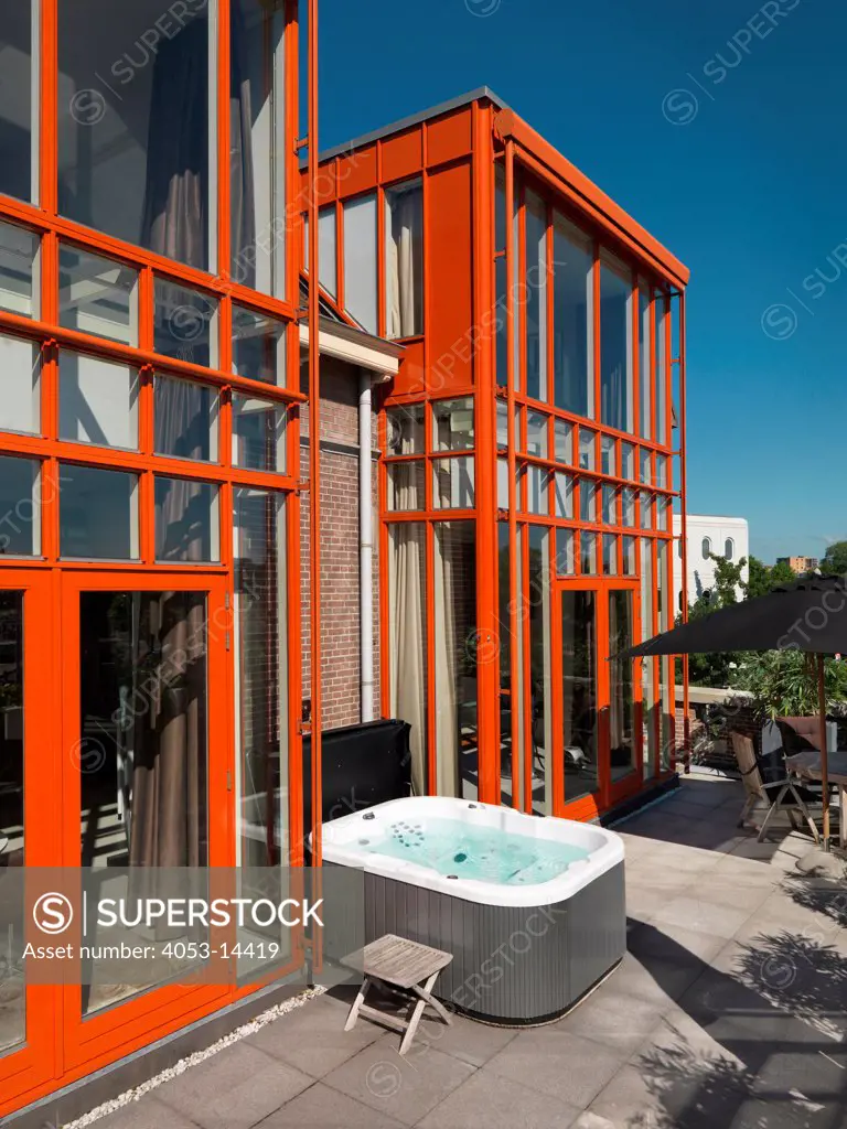 Outdoor furniture and Jacuzzi in patio by apartment against blue sky. Amsterdam, Netherlands. 08/10/2012