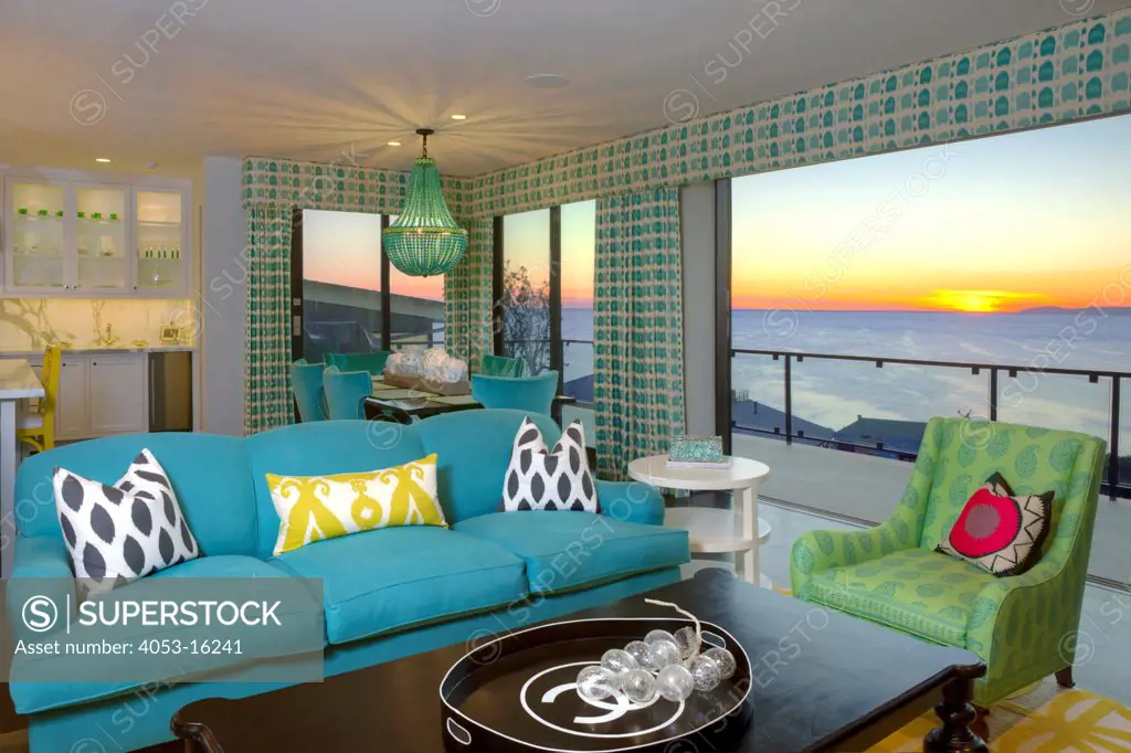 Open plan living room and dining area with view of sunset through window, Laguna Beach, California, USA. 12/22/2011