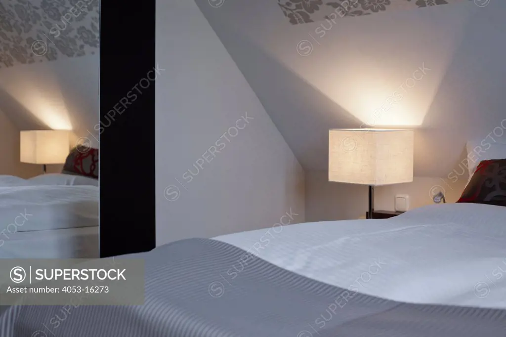 Lit lamp in bedroom of contemporary house, Arunshoup, Germany.