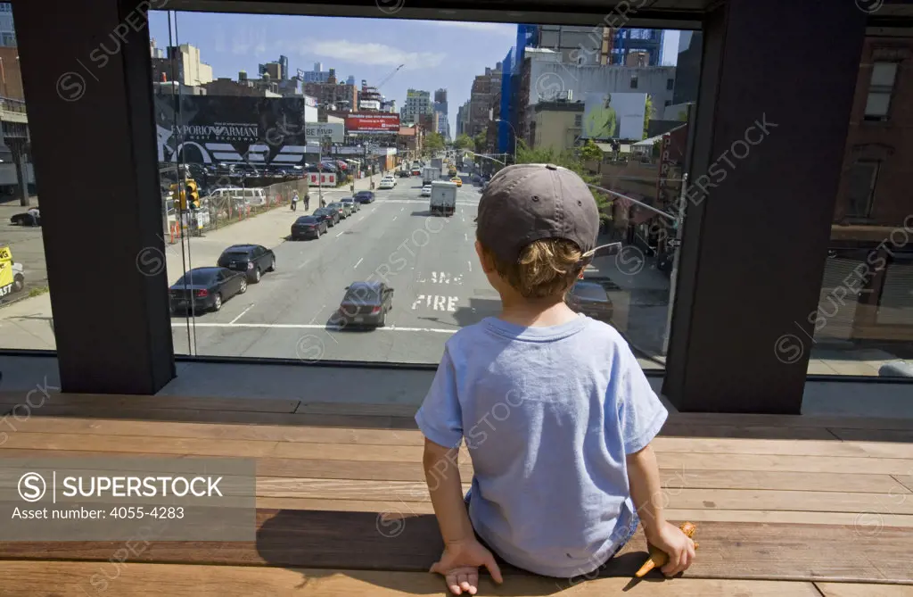 Young boy looks at traffic over 10th Avenue from the High LIne Park, Chelsea, Manhattan, New York (MR)