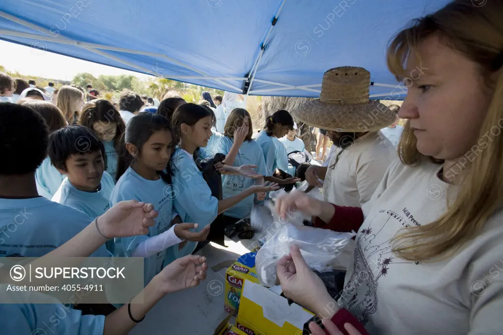 Handing our gloves and bags. Over 700 school children attended the River School Day clean up of the LA River sponsered by FoLAR (Friends of the Los Angeles River), Glendale Narrows, Los Angeles, California, USA