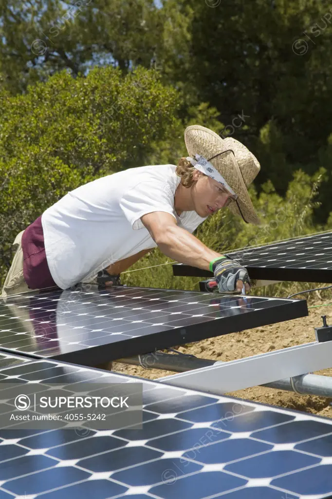 Green workers install a residential grid-tied solar array on a hillside in Malibu, Installation by Martifer Solar USA, California, USA