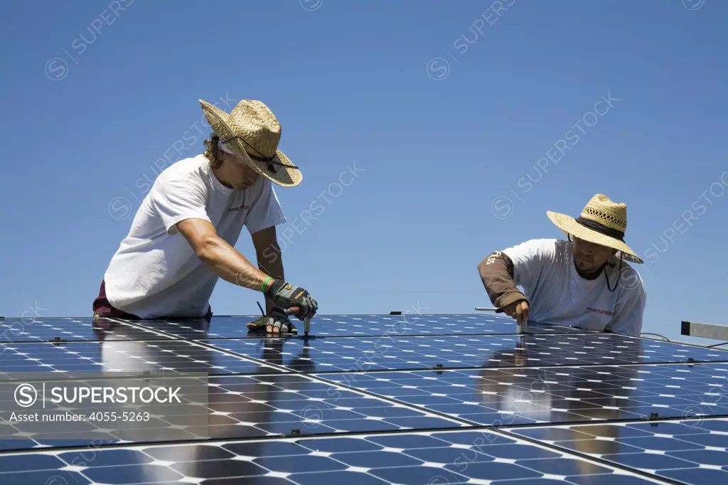 Green workers install a residential grid-tied solar array on a hillside in Malibu, Installation by Martifer Solar USA, California, USA