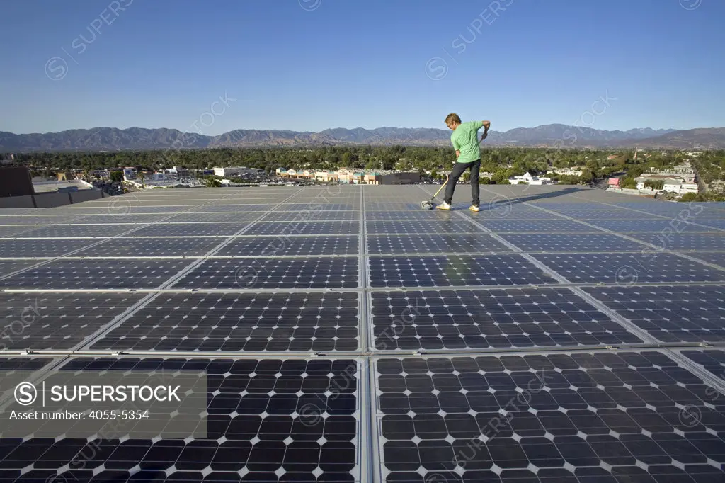 Cleaning Solar panels. Array on rooftop  of office building in Panorama City, San Fernando Valley, Los Angeles, California, USA
