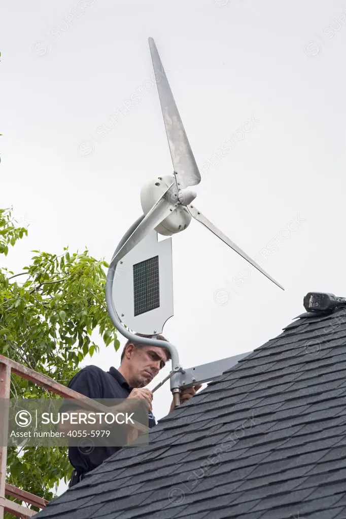 Installation of a residential wind turbine is filmed for an episode of the DIY network show ""This New House"". Bob Hayes of Prevailing Winds and his crew install a Dyocore SolAir 800 I wind turbine which integrates two small solar panels into its design and is capable of producing up to 800 Watts at 12 mph. The two solar panels produce up to 45watts. Redondo Beach, Ca, USA