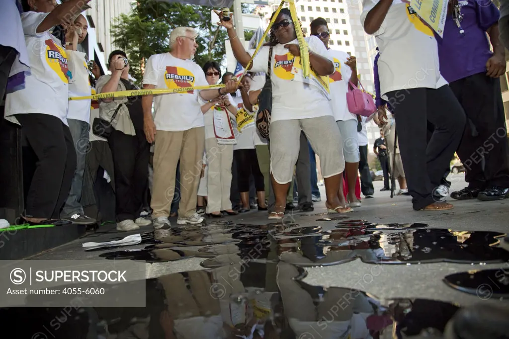 Protesters pour fake oil on the sidewalk in front of Occidental Petroleum offices. On July 22, 2010, over a thousand protesters marched to Occidental Petroleum offices in Westwood, Los Angeles to demonstrate against the California state loophole that allows oil companies to extract oil, tax free.