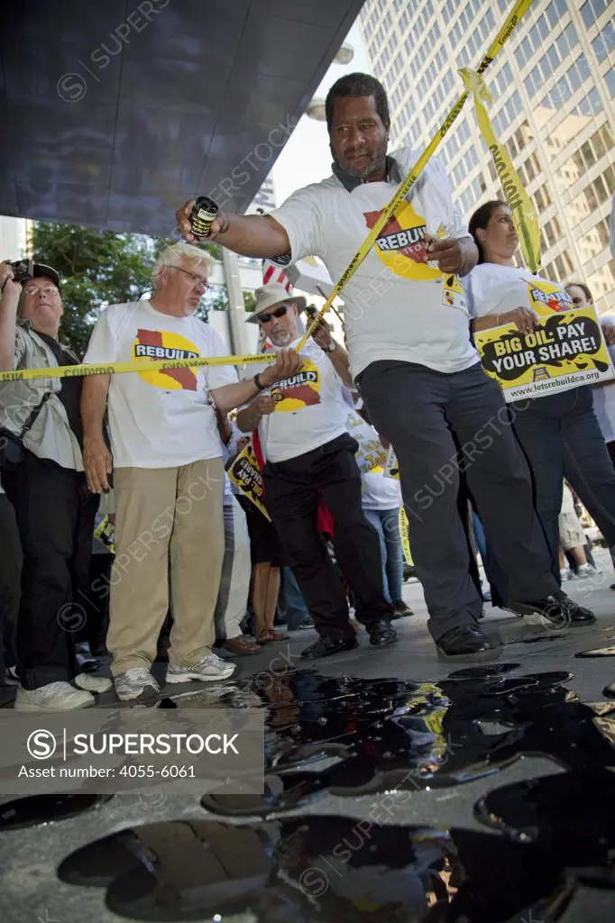 Protesters pour fake oil on the sidewalk in front of Occidental Petroleum offices. On July 22, 2010, over a thousand protesters marched to Occidental Petroleum offices in Westwood, Los Angeles to demonstrate against the California state loophole that allows oil companies to extract oil, tax free.