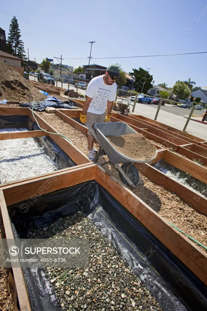 July 24, 2010. Laying down the soil for the final preparations of the planting beds at the Venice Community Garden. The 2 foot deep beds are layered with 3 inches of rocks as a buffer between the roots and the bad soil below, but will still allow water to drain.