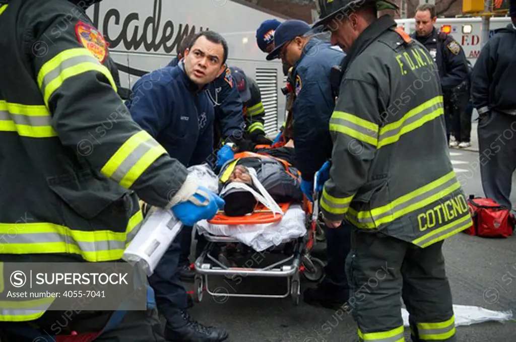 First responders remove a bicyclist into an ambulance after being hit by a turning bus in the New York neighborhood of Chelsea, on the eastern corner of West 26th Street and Ninth Avenue, in New York on Friday, December 10, 2010. Authorities are investigating the accident.  (© Frances M. Roberts)