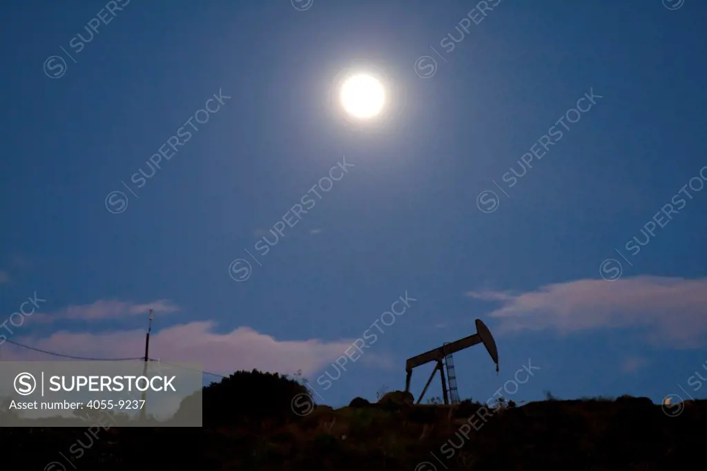 Oil derrick by moonlight. The 1200-acre Inglewood Oil Field located in the Baldwin Hills area is the largest urban oil field in the United States and is surrounded by over 300 homes in the communities of Culver City, Baldwin Hills, Inglewood and Los Angeles. Los Angeles County, California, USA