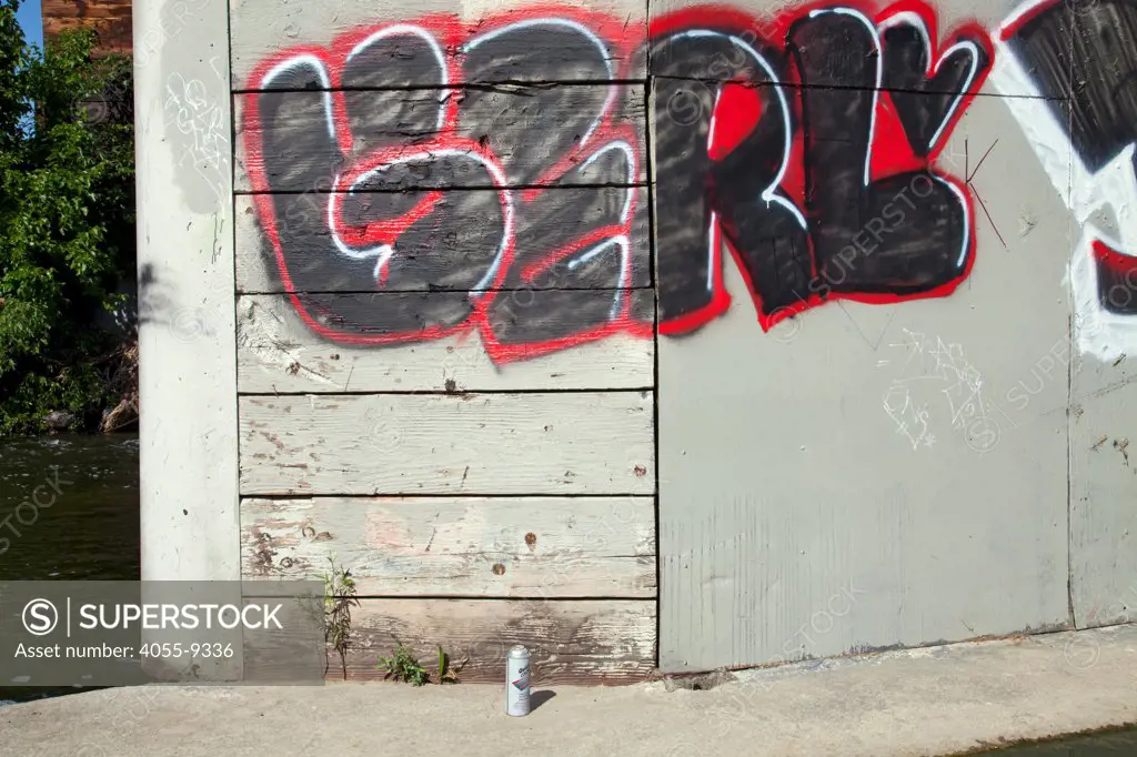 Spray paint can and graffiti under pedestrian bridge along the Glendale Narrows, Los Anglees River, California