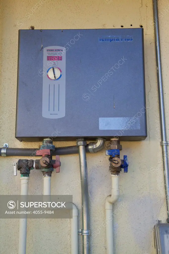 Tankless water heater on side of Green home that is off the grid. Solar power and a rainwater harvesting system supply all the energy and water for this home in Los Angeles, California, USA