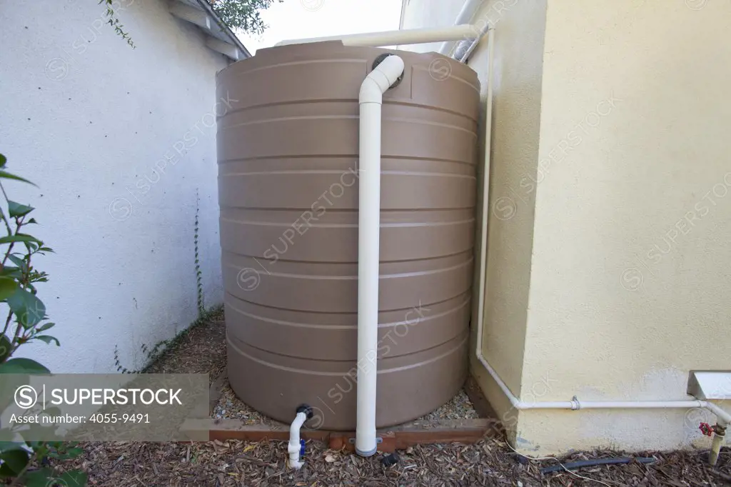 865 gallon rain barrel next to Green home that is off the grid. Solar power and a rainwater harvesting system supply all the energy and water for this home in Los Angeles, California, USA