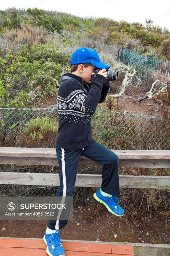 Young boy taking photos with a camera, Elfin Forest, Baywood Park, San Luis Obispos County, California, USA (MR)