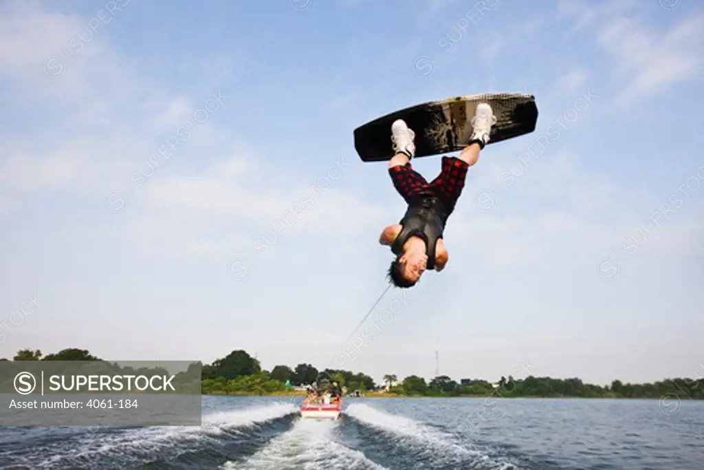 Young man performing wakeboarding stunts