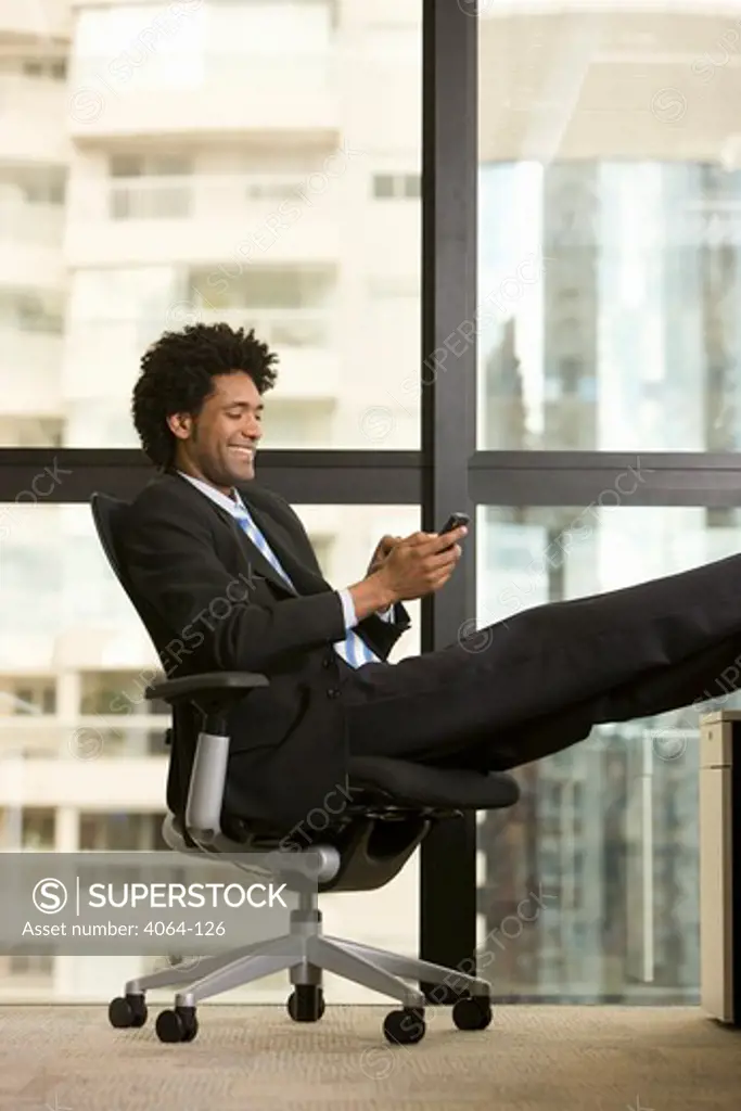 Businessman text messaging on a mobile phone in an office