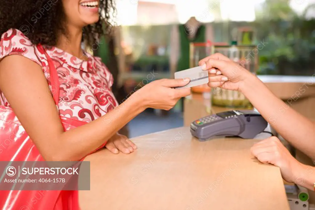 Woman paying through credit card at the checkout counter in a clothing store