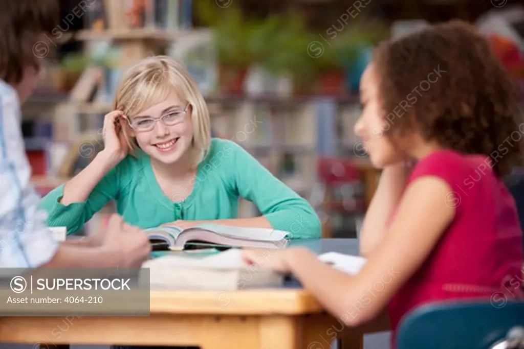 Middle school students talking in a library