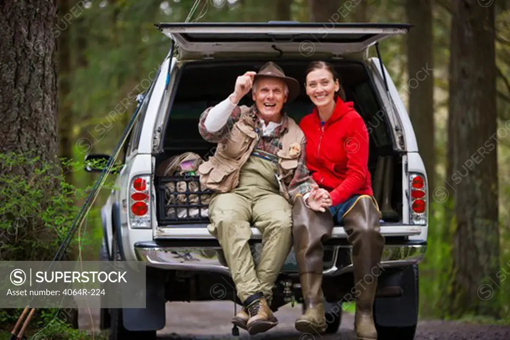 USA, Washington, Vancouver, Portrait of smiling couple sitting in back of car after fishing