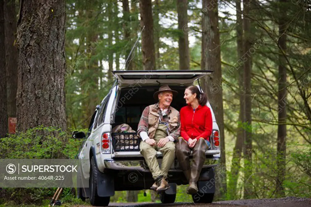 USA, Washington, Vancouver, Smiling couple sitting in back of car after fishing