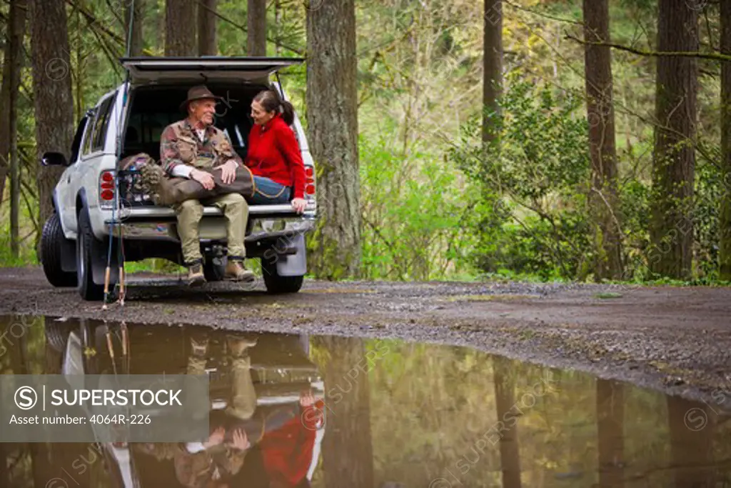 USA, Washington, Vancouver, Smiling couple sitting in back of car after fishing