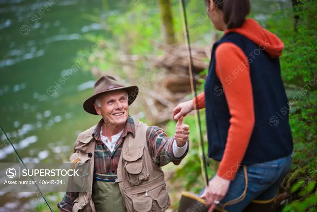 USA, Washington, Vancouver, Smiling couple with fishing rods by river