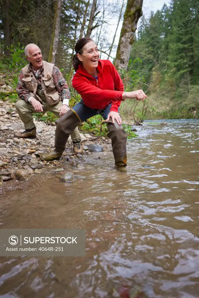 USA, Washington, Vancouver, Couple skipping stones on river