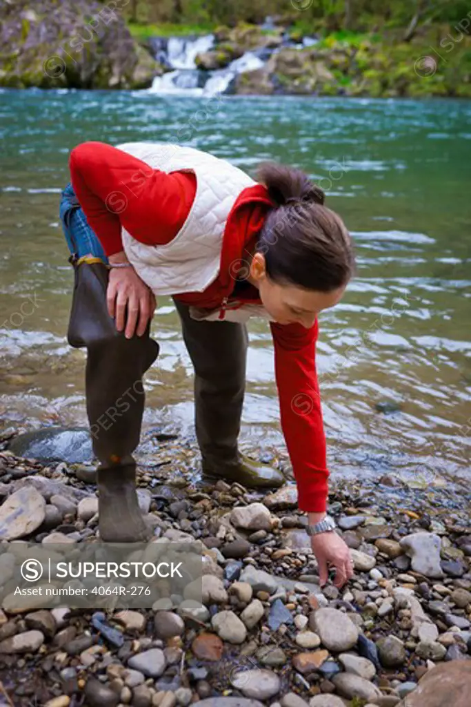 USA, Washington, Vancouver, Woman skipping stones in river