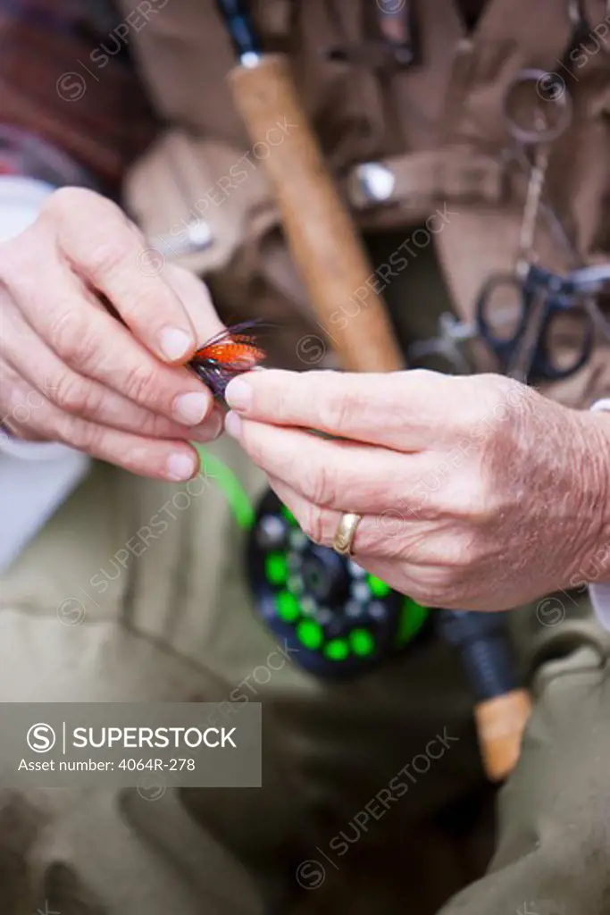 USA, Washington, Vancouver, Close-up of fisherman's hands tying fly onto line