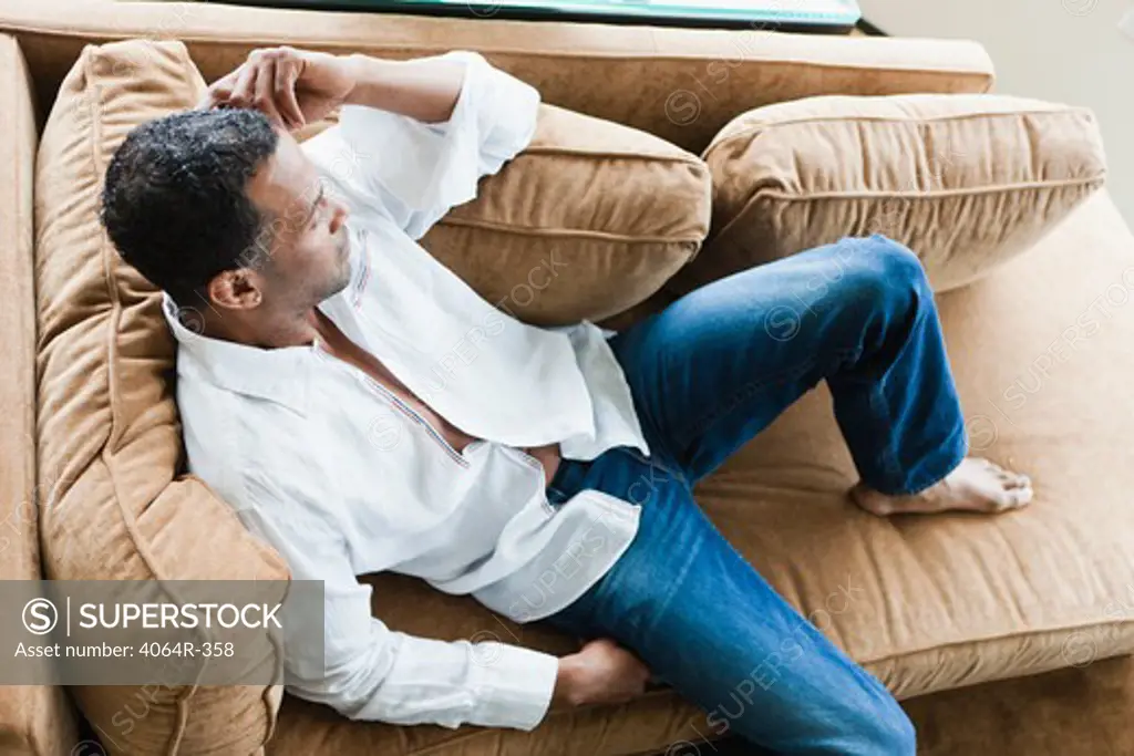 Man relaxing on sofa in loft apartment