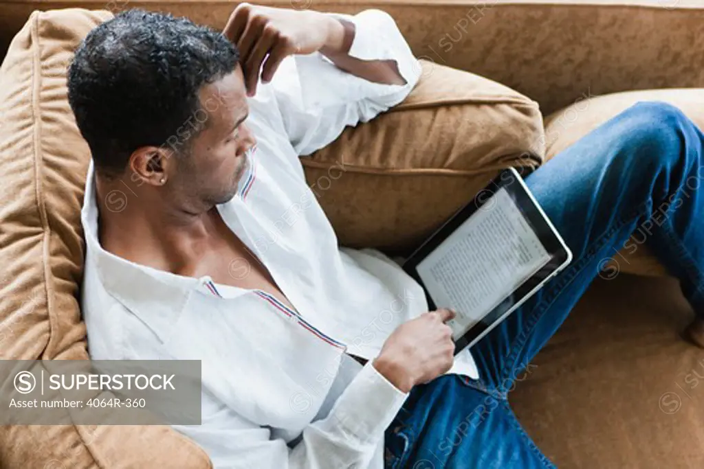Man sitting on couch with ebook